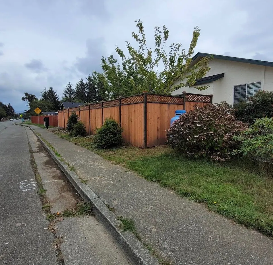 Cedar privacy fence with lattice top wrapping a corner lot along the sidewalk