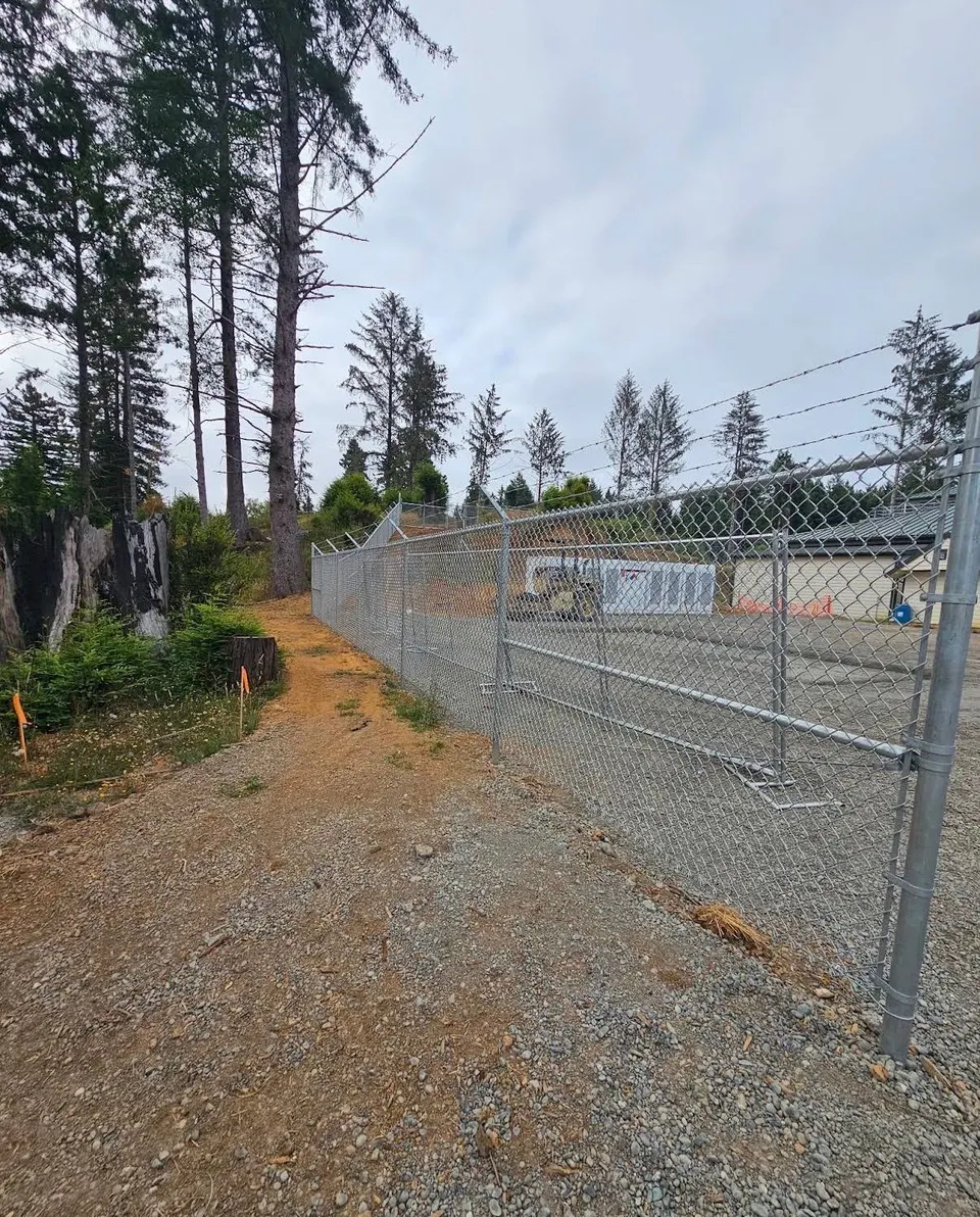 New galvanized chain-link fence and gates enclosing a commercial yard