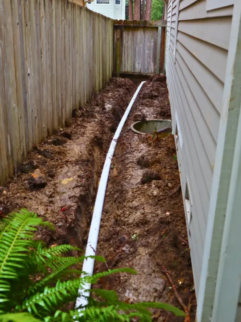 Gravel drainage installed beneath a fence line