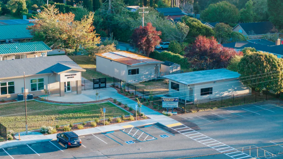 Aerial view of a school entrance with new walkways, planting beds, and parking