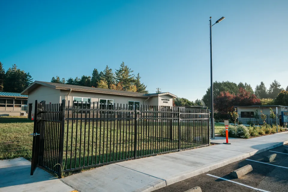 Black ornamental steel security fence running along a school perimeter