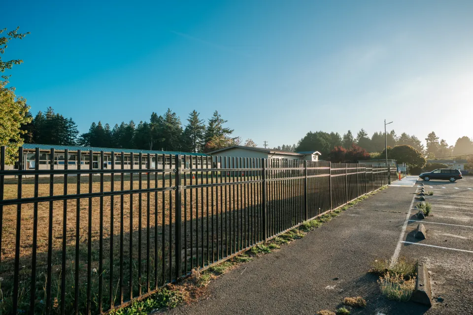 Long run of steel perimeter fence along the edge of a school field