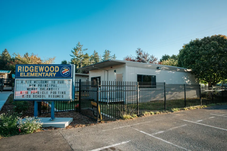 Ornamental steel perimeter fence enclosing a school parking area