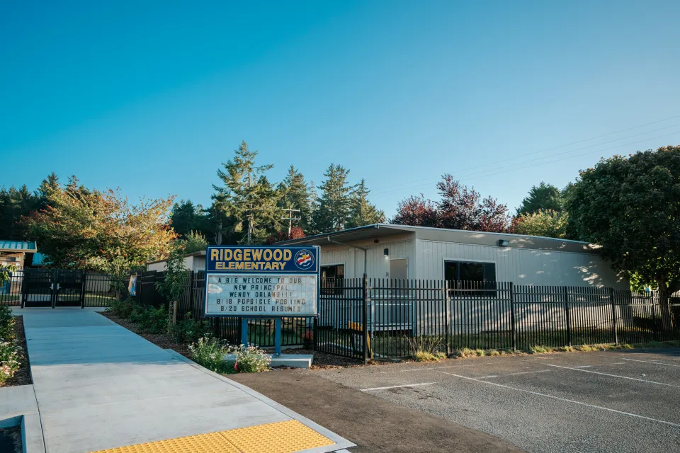School marquee sign framed by new security fence and landscape planting