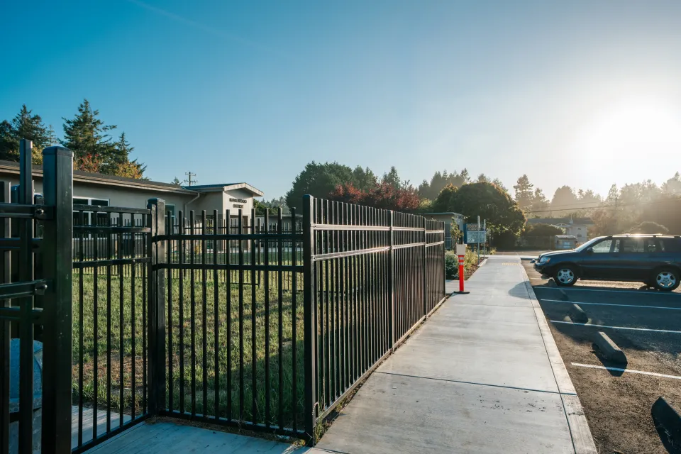Steel security gate at a school entrance beside a new concrete walkway