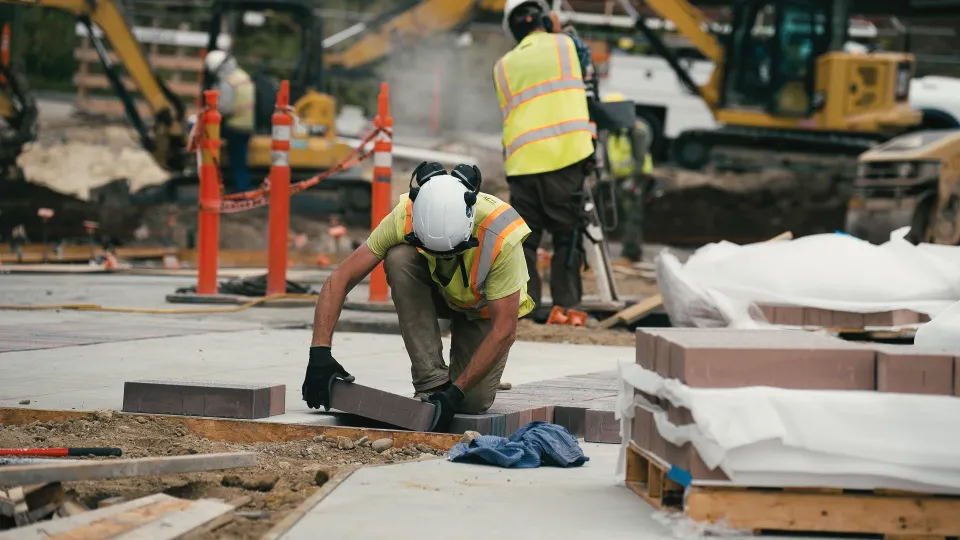 Crew member setting a large format paver into a commercial walkway