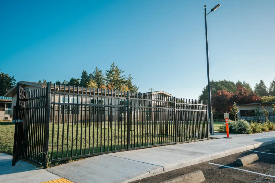 Steel picket security fence line along a concrete curb at a school